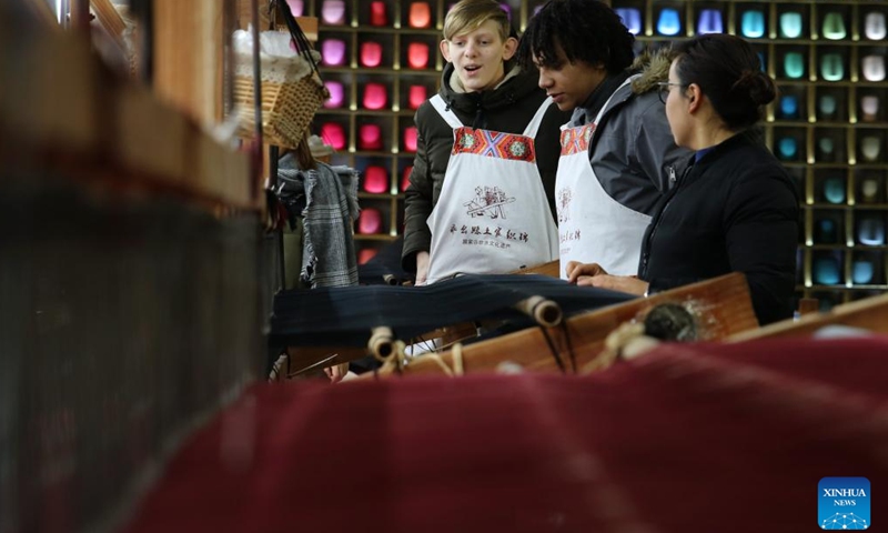 International visitors get acquainted with the Tujia traditional hand-made brocades at the Guaiyaomei Tujia ethnic brocade innovative factory in Zhangjiajie, central China's Hunan Province, Jan. 30, 2018. (Xinhua)