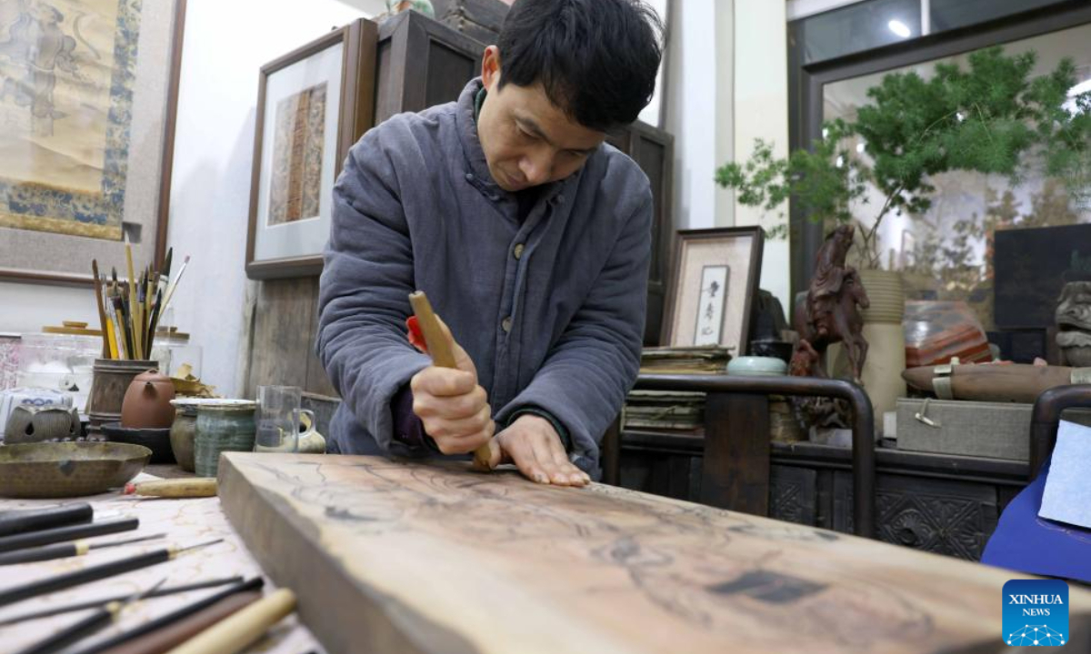 Tong Min makes a woodcut at a studio in Hefei, east China's Anhui Province, Feb 4, 2024. Photo:Xinhua