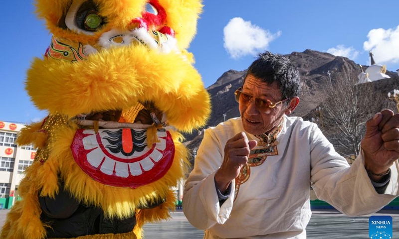 Tengpa Anye (R) instructs students to perform lion dance at a primary school in Xobando Town of Lhorong County in Qamdo City, southwest China's Xizang Autonomous Region, Jan. 19, 2024.(Xinhua/Sun Fei)