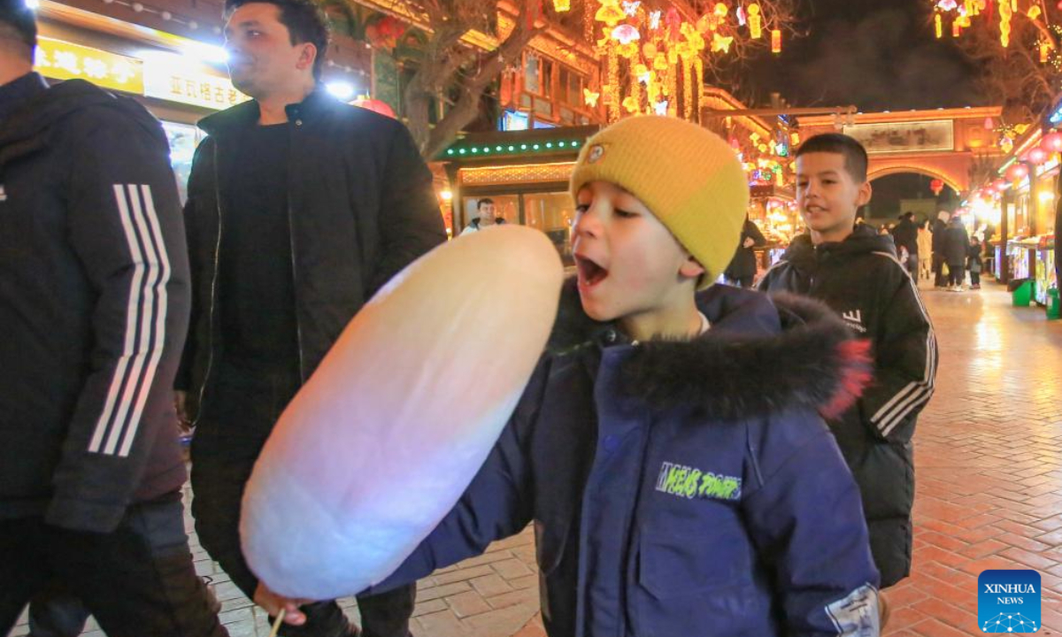 A child eats cotton candy at a night market in the ancient city of Kashgar, northwest China's Xinjiang Uygur Autonomous Region, Feb 4, 2024. Photo:Xinhua