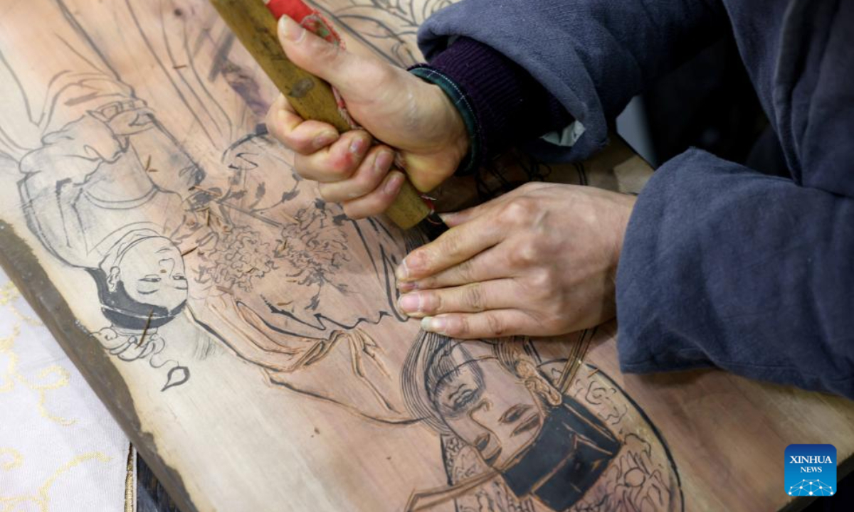Tong Min makes a woodcut at a studio in Hefei, east China's Anhui Province, Feb 4, 2024. Photo:Xinhua