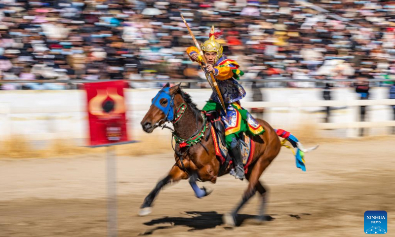 A rider performs riding and archery in Lhasa, southwest China's Xizang Autonomous Region, Feb. 12, 2024. The equestrian team of southwest China's Xizang Autonomous Region staged a thrilling display of traditional horse racing in its capital Lhasa on Monday, the third day of the Tibetan New Year. The riders were dressed in colorful Tibetan clothes and galloped gracefully around the racecourse in the northern suburbs of Lhasa. (Photo: Xinhua)
