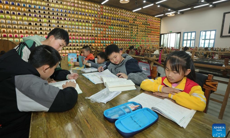 This undated file photo shows artisans' children studying at the Guaiyaomei Tujia ethnic brocade innovative factory in Zhangjiajie, central China's Hunan Province. (Xinhua)