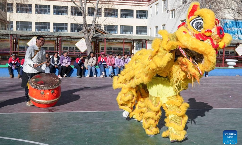 Tengpa Anye (L) plays the drum as his students perform lion dance at a primary school in Xobando Town of Lhorong County in Qamdo City, southwest China's Xizang Autonomous Region, Jan. 19, 2024.(Xinhua/Sun Fei)