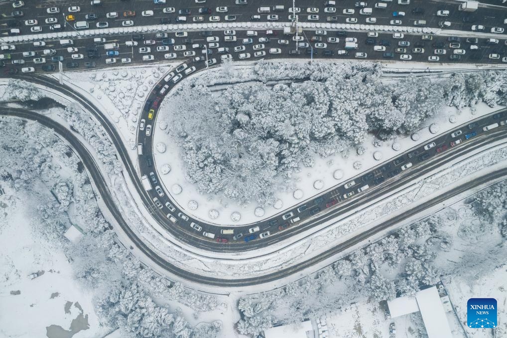 An aerial drone photo taken on Jan. 22, 2024 shows vehicles running on the road in Changsha, central China's Hunan Province. Changsha saw its first snowfall of 2024 from Sunday night to Monday morning(Photo: Xinhua)