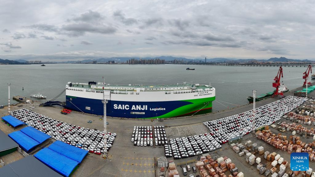 An aerial panoramic drone photo taken on Jan. 23, 2024 shows vehicles to be exported and SAIC Anji Sincerity ro-ro ship at Dongdu port area in Xiamen, southeast China's Fujian Province. More than 3,700 cars were loaded into the ro-ro ship at Dongdu port area in Xiamen on Tuesday. The ship will depart from Xiamen on January 24 for Europe, which will be the largest batch of automobile export by far from Xiamen Port on a single voyage.(Photo: Xinhua)