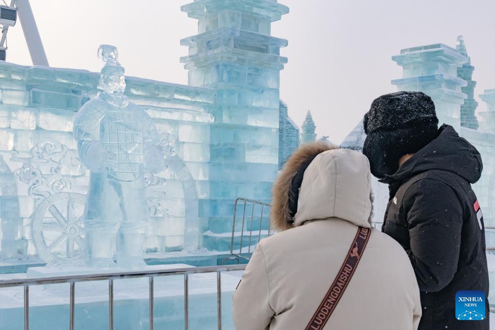 Visitors look at an ice sculpture of a Terracotta Warrior in Harbin Ice and Snow World in Harbin, northeast China's Heilongjiang Province, Jan. 23, 2024. As a group of AI-generated images of ice sculptures of Terracotta Warriors went viral on the internet, artists created a series of ice sculptures of Terracotta Warriors at Harbin Ice and Snow World to attract visitors(Photo: Xinhua)