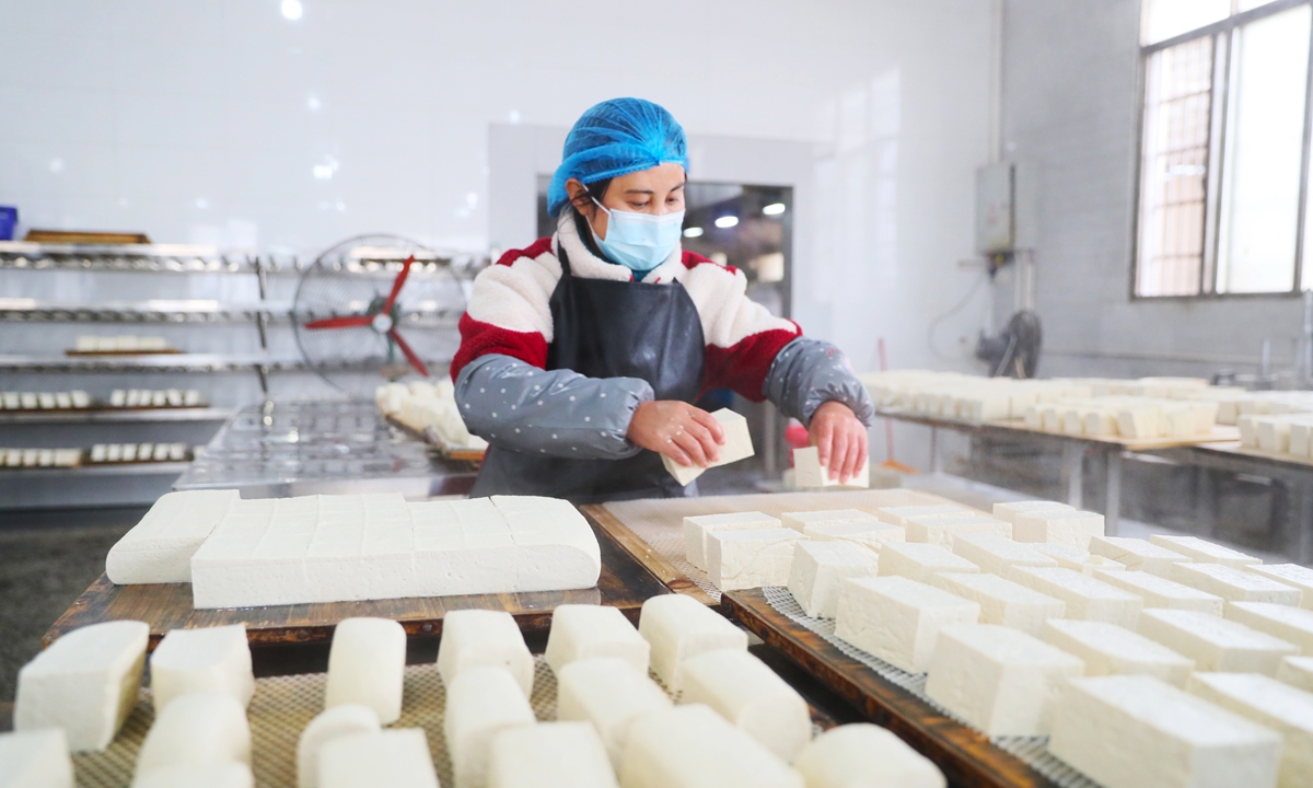 An employee produces tofu at a workshop in the city of Yongzhou, Central China's Hunan Province on January 24, 2024 in preparation for the upcoming Chinese Spring Festival holidays in February. The tofu industry has become a thriving business, creating jobs and contributing to local economic development. Photo: VCG