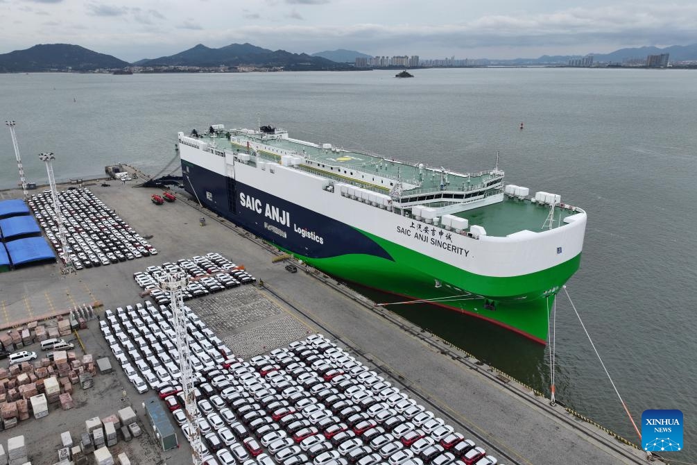 An aerial drone photo taken on Jan. 23, 2024 shows vehicles to be exported and SAIC Anji Sincerity ro-ro ship at Dongdu port area in Xiamen, southeast China's Fujian Province. More than 3,700 cars were loaded into the ro-ro ship at Dongdu port area in Xiamen on Tuesday. The ship will depart from Xiamen on January 24 for Europe, which will be the largest batch of automobile export by far from Xiamen Port on a single voyage.(Photo: Xinhua)