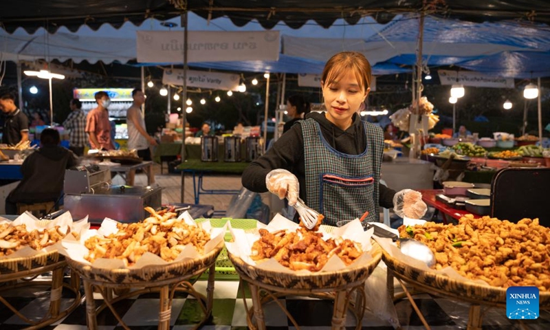 A vendor sells food during Lao Food Festival in Vientiane, capital of Laos on Jan. 23, 2024. The annual Lao Food Festival is held here from January 23 to 27.(Photo: Xinhua)