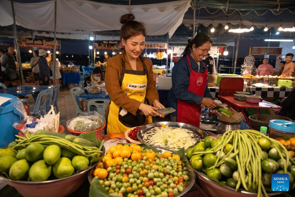 A vendor sells food during Lao Food Festival in Vientiane, capital of Laos on Jan. 23, 2024. The annual Lao Food Festival is held here from January 23 to 27.(Photo: Xinhua)