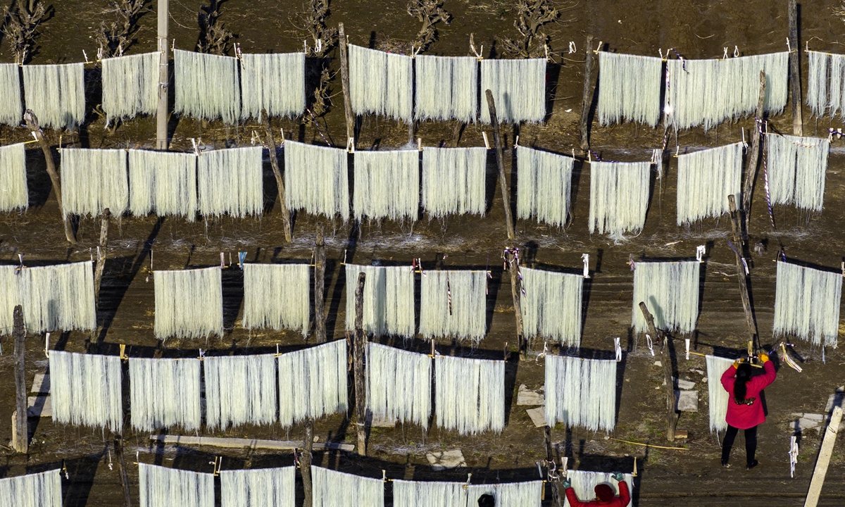 Villagers air-dry glass noodles in the sun to meet the festival demand in Gaojiayan town, East China's Jiangsu Province on January 25, 2024. Noodle processing has become a major source of income for rural areas in Gaojiayan town. Popular both at home and abroad, they are exported to South Korea and sold domestically in more than 10 provinces and cities through online and offline channels. Photo: VCG 