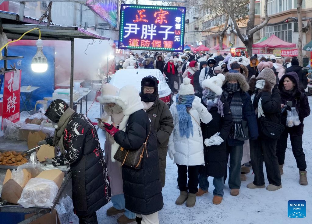 Tourists queue for fried brown sugar cakes at the Hongzhuan Morning Market in Harbin, northeast China's Heilongjiang Province, Jan. 22, 2024. Harbin's morning markets, known for their diverse offerings at reasonable prices, have been a hot spot for tourists.The morning market on Hongzhuan Street has been one of the first local morning markets to gain fame recently. Food stalls serving steaming local breakfast dishes are bustling with tourists eager to taste local delicacies.(Photo: Xinhua)