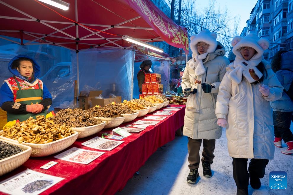 Tourists pass a mushroom stall at the Hongzhuan Morning Market in Harbin, northeast China's Heilongjiang Province, Jan. 22, 2024. Harbin's morning markets, known for their diverse offerings at reasonable prices, have been a hot spot for tourists.The morning market on Hongzhuan Street has been one of the first local morning markets to gain fame recently. Food stalls serving steaming local breakfast dishes are bustling with tourists eager to taste local delicacies.(Photo: Xinhua)