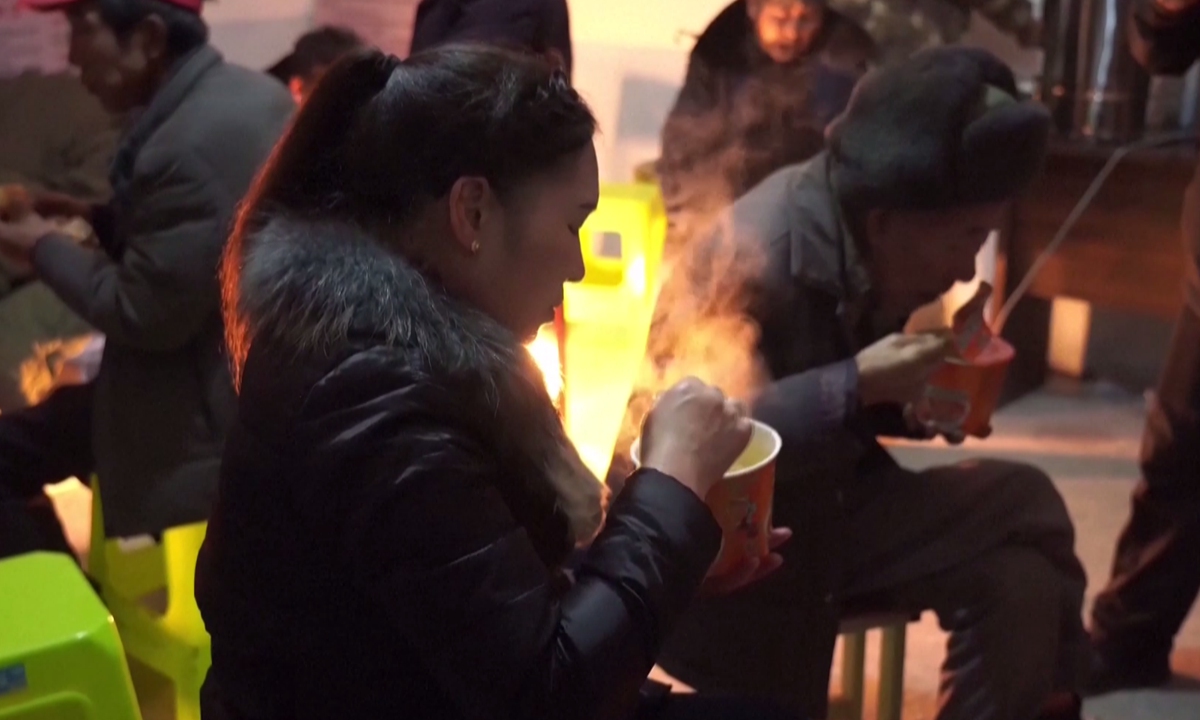 Landslide-affected residents in the Liangshui village in Zhenxiong, Yunnan, eat instant noodles in temporary relocation sites, on January 22, 2024. Photo: VCG