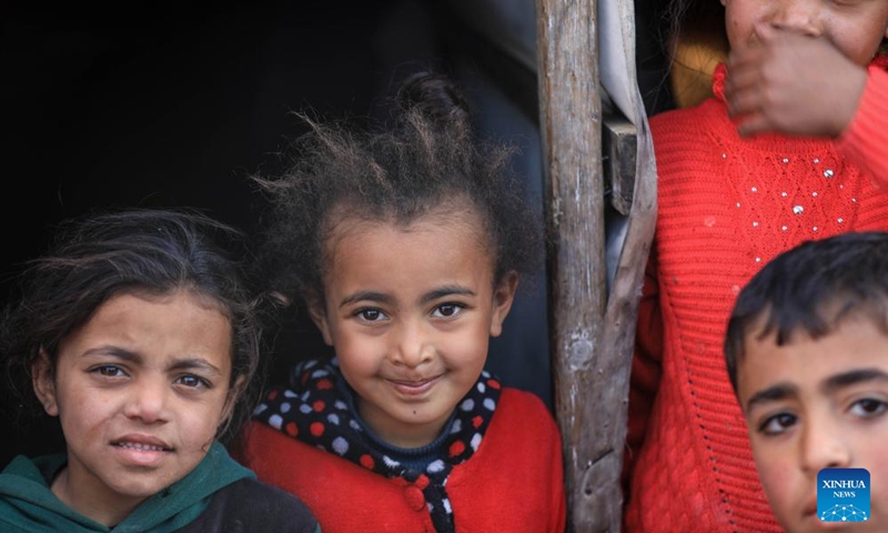 Children are seen at a temporary camp in the southern Gaza Strip city of Rafah, on Jan. 26, 2024. The Palestinian death toll from the ongoing Israeli attacks on the Gaza Strip has risen to 26,083 since Oct. 7, 2023, the Hamas-run Health Ministry said on Friday. (Photo by Yasser Qudih/Xinhua)