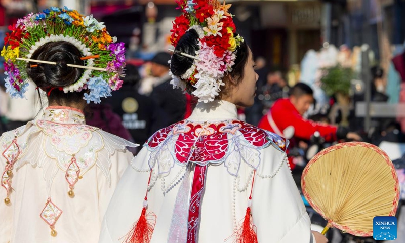 Tourists wearing flowery headwear are seen at Xunpu Village of Quanzhou City, southeast China's Fujian Province, Jan. 26, 2024. (Xinhua/Wei Peiquan)