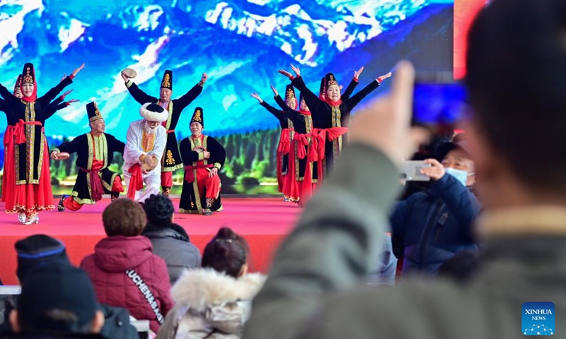 People watch performance during a fair in preparation for the upcoming Spring Festival at the Xinjiang International Convention and Exhibition Center in Urumqi, northwest China's Xinjiang Uygur Autonomous Region, Jan. 27, 2024. (Xinhua/Ding Lei)