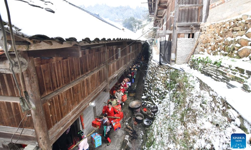 Villagers carrying gifts are pictured on their way to attend a feast at Dangjiu Village in Gandong Township of Rongshui Miao Autonomous County, south China's Guangxi Zhuang Autonomous Region, Jan. 24, 2024. Miao ethnic people in high mountainous villages of Liuzhou are busy preparing celebratory merchandise, hosting feasts, and rehearsing festive events ahead of the upcoming Chinese New Year despite the freezing weather. (Xinhua/Huang Xiaobang)