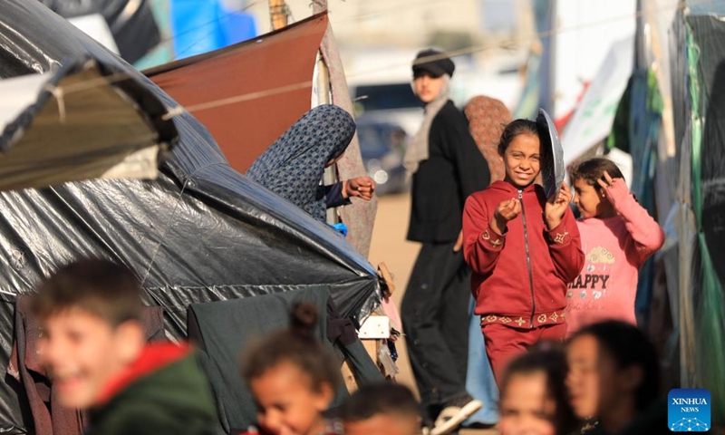 Children are seen at a temporary camp in the southern Gaza Strip city of Rafah, on Jan. 26, 2024. The Palestinian death toll from the ongoing Israeli attacks on the Gaza Strip has risen to 26,083 since Oct. 7, 2023, the Hamas-run Health Ministry said on Friday. (Photo by Yasser Qudih/Xinhua)