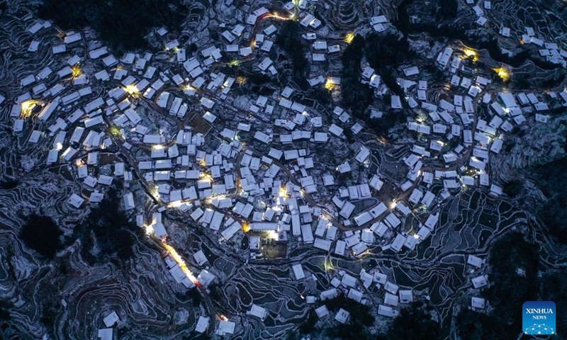 An aerial drone photo taken on Jan. 24, 2024 shows the night view of Jindong Village in Gandong Township of Rongshui Miao Autonomous County, south China's Guangxi Zhuang Autonomous Region. Miao ethnic people in high mountainous villages of Liuzhou are busy preparing celebratory merchandise, hosting feasts, and rehearsing festive events ahead of the upcoming Chinese New Year despite the freezing weather. (Xinhua/Huang Xiaobang)