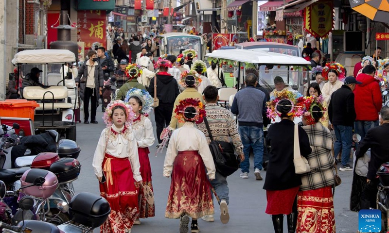 Tourists wearing flowery headwear are seen at Xunpu Village of Quanzhou City, southeast China's Fujian Province, Jan. 26, 2024.(Xinhua/Wei Peiquan)
