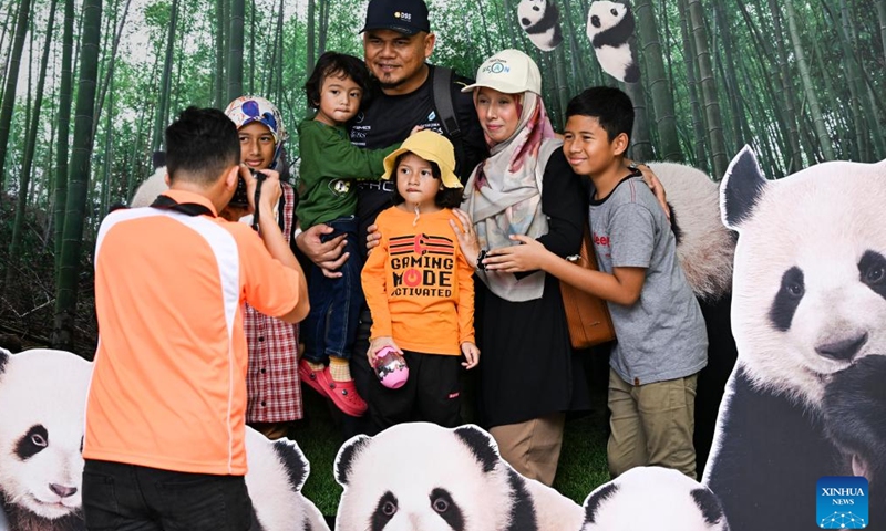 Visitors pose for photos with images of panda at Zoo Negara near Kuala Lumpur, Malaysia, Jan. 27, 2024. Malaysia is looking into extending the period of stay of two giant pandas Xing Xing and Liang Liang at Zoo Negara, Prime Minister Anwar Ibrahim said on Saturday. (Xinhua/Cheng Yiheng)