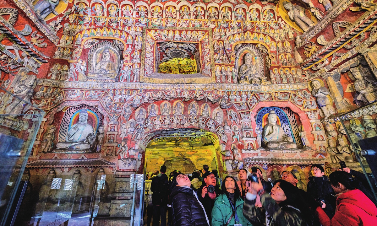 Visitors in a cave of the Yungang Grottoes Photo:VCG 