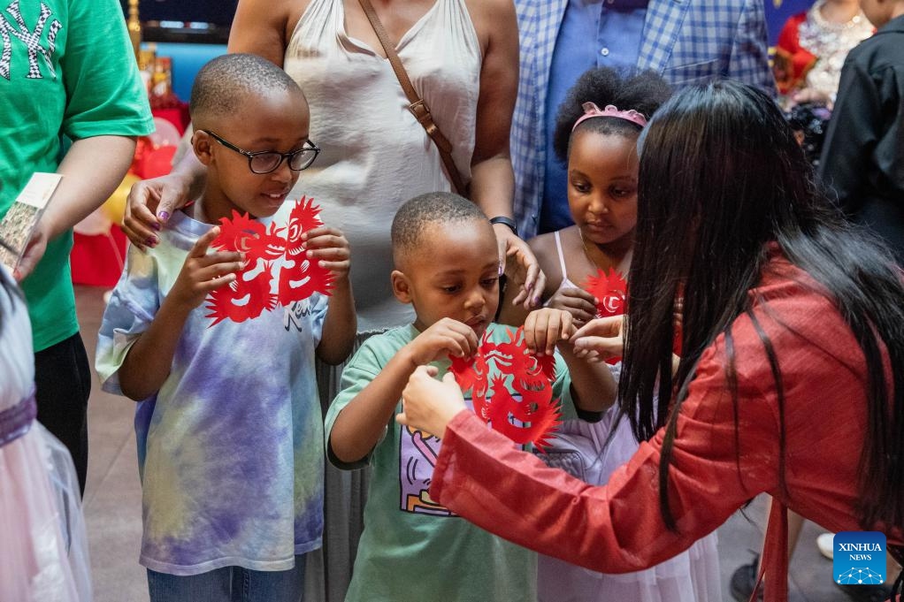 Children receive paper cutting works during the 2024 Happy Chinese New Year Gala in Pretoria, South Africa, Jan. 29, 2024.(Photo: Xinhua)