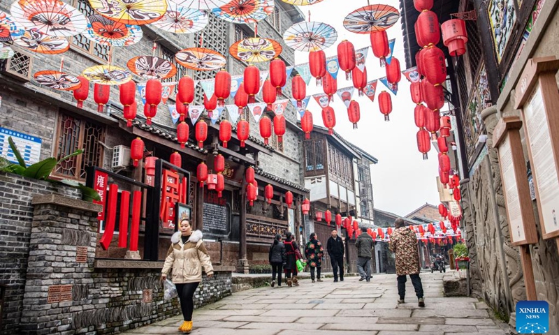 Residents walk in Yongxi ancient town in Dazu District of southwest China's Chongqing Municipality, Jan. 30, 2024. Decorations have been set up in the town to celebrate the upcoming Chinese Lunar New Year, or the Spring Festival.(Photo: Xinhua)
