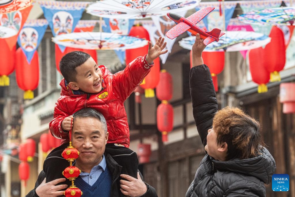 Residents walk in Yongxi ancient town in Dazu District of southwest China's Chongqing Municipality, Jan. 30, 2024. Decorations have been set up in the town to celebrate the upcoming Chinese Lunar New Year, or the Spring Festival.(Photo: Xinhua)