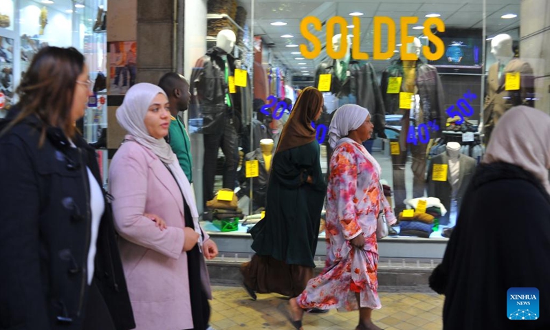 People walk past a sale sign outside a store in the central business district of Tunis, Tunisia, on Feb. 1, 2024. The annual winter sale season started here on Thursday.(Photo: Xinhua)