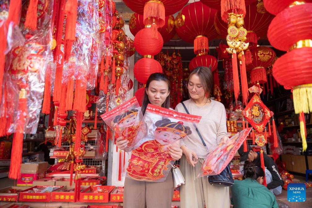 Customers select Spring Festival decorations at a local market in Vientiane, capital of Laos, Feb. 1, 2024.(Photo: Xinhua)