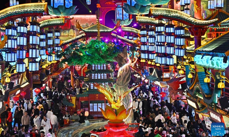 People visit a scenic spot in Chengyang District of Qingdao, east China's Shandong Province, on Feb. 10, 2024. Light installations and stage performances have been arranged here to attract more nighttime visitors during the Spring Festival holiday. (Xinhua/Li Ziheng)