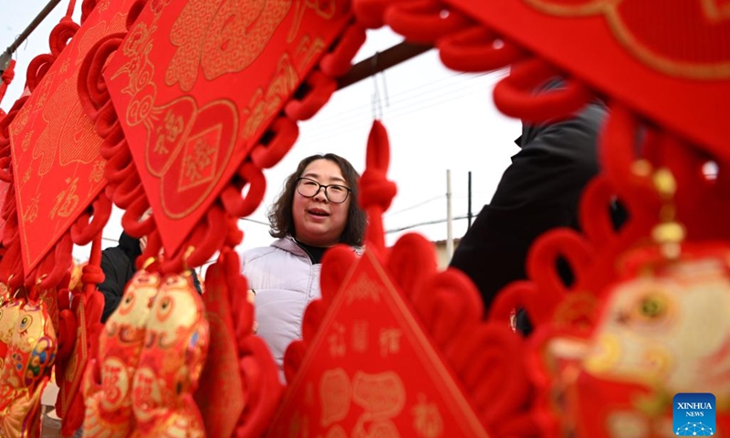 Customers visit a stall selling Spring Festival decorations at a fair in Sicundian Town of Wuqing District, north China's Tianjin, Feb. 4, 2024.A fair was held in Sicundian Town to greet the upcoming Chinese New Year, attracting locals to buy traditional Spring Festival goods and specialties and watch performances. (Xinhua/Li Ran)