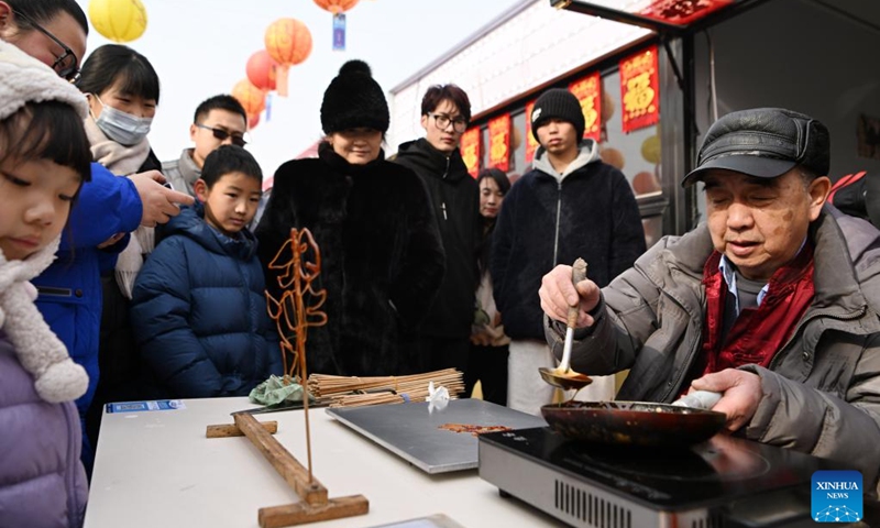 A craftsman makes sugar figurines at a fair in Sicundian Town of Wuqing District, north China's Tianjin, Feb. 4, 2024.A fair was held in Sicundian Town to greet the upcoming Chinese New Year, attracting locals to buy traditional Spring Festival goods and specialties and watch performances. (Xinhua/Li Ran)