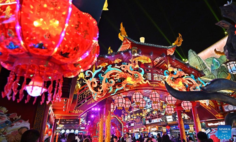 People visit a scenic spot in Chengyang District of Qingdao, east China's Shandong Province, on Feb. 10, 2024. Light installations and stage performances have been arranged here to attract more nighttime visitors during the Spring Festival holiday. (Xinhua/Li Ziheng)