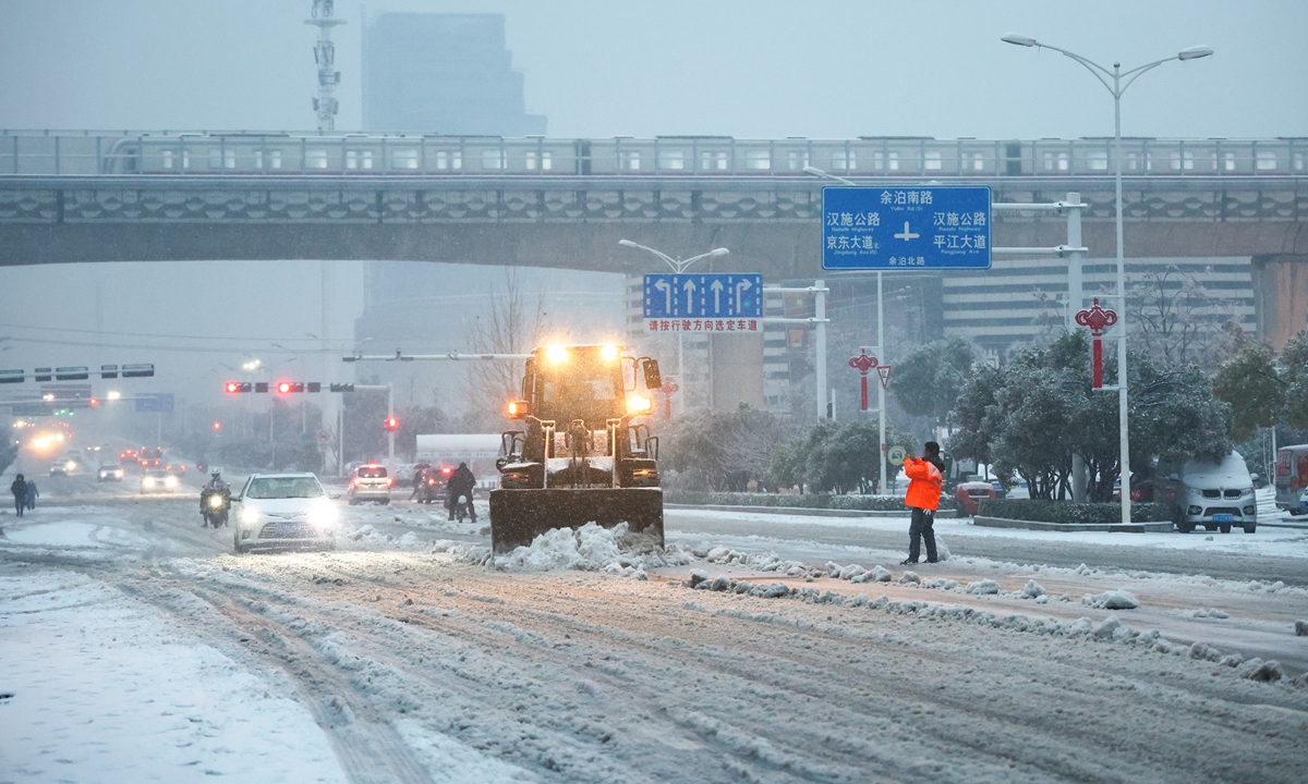 Sanitation workers brave the snow to thaw ice and clear downed and broken trees on the roadside to help keep traffic going as heavy snow falls in Wuhan, Central China's Hubei Province, on February 4, 2024. Photo: VCG