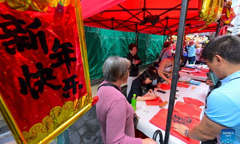 Artists write Spring Festival couplets during an event celebrating the upcoming Chinese New Year at the Temple Street in south China's Hong Kong, Feb. 4, 2024. (Xinhua/Zhu Wei)