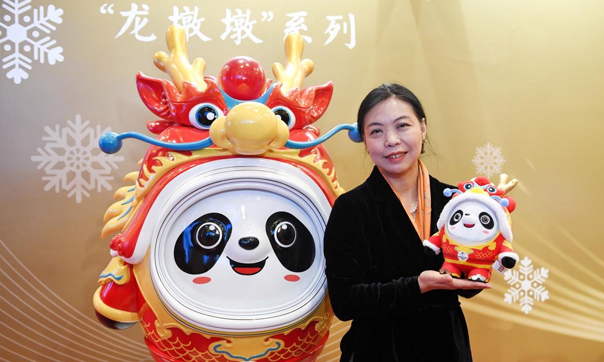 Lin Cunzhen poses with a dragon version of Bing Dwen Dwen Photo: Xinhua