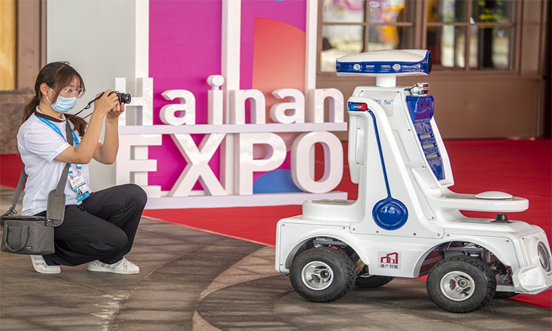 A participant at the first China International Consumer Products Expo (CICPE) takes a picture of a patrol robot at the expo center on May 6, 2021. Photo: IC