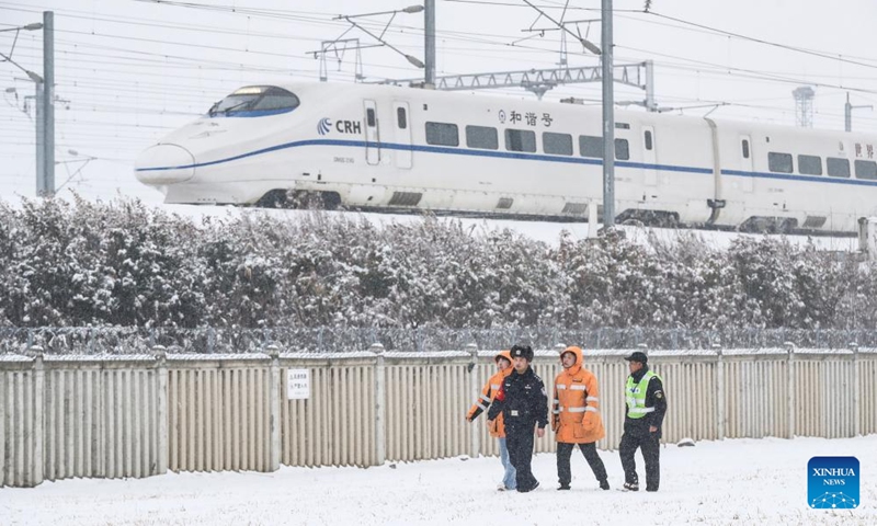 Policemen and high-speed railway infrastructure workers patrol the railway in Huai'an City, east China's Jiangsu Province, Feb. 4, 2024. Heavy snowfall has hit some areas of central and eastern China since Wednesday, leading to transport disruption amid the ongoing Spring Festival travel rush. (Photo by Zhao Qirui/Xinhua)