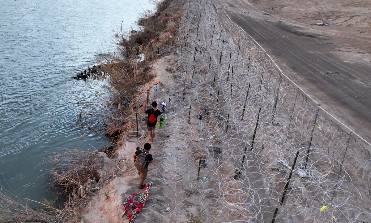 An aerial view of migrants walking next to razor wire as they try to cross the Texas border to seek humanitarian asylum on February 5 local time, 2024 in El Paso, Texas.The border issue is regarded as a political liability for US President Joe Biden that Republicans are eager to put front and center to voters in an election year. Photo: VCG
