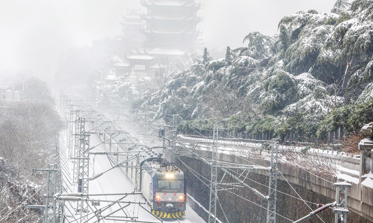A train passes by Yellow Crane Tower, or Huanghelou, a landmark in Wuhan, Central China's Hubei Province, on February 6, 2024. The province is still under an orange alert for rain, snow and freezing weather with lows forecast to reach below -2 C. Photo: VCG
