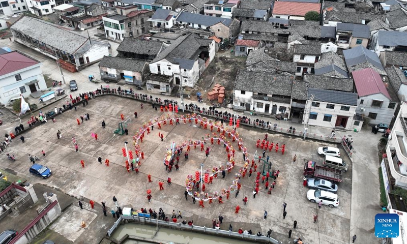 An aerial drone photo taken on Feb. 5, 2024 shows actors performing lantern dragon dance at a square in Fengjiangzhou Village of Zhuji City, east China's Zhejiang Province. The lantern dragon dance, a local traditional custom, was staged here on Monday in celebration of the upcoming Chinese Spring Festival.(Photo: Xinhua)