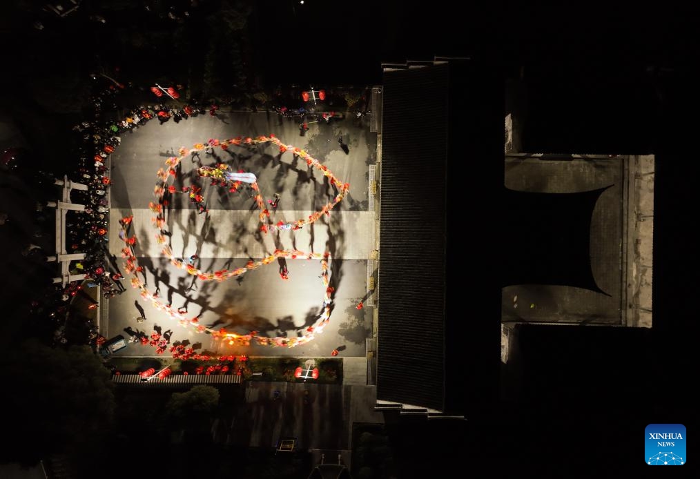 An aerial drone photo taken on Feb. 5, 2024 shows actors performing lantern dragon dance at a square in Fengjiangzhou Village of Zhuji City, east China's Zhejiang Province. The lantern dragon dance, a local traditional custom, was staged here on Monday in celebration of the upcoming Chinese Spring Festival.(Photo: Xinhua)
