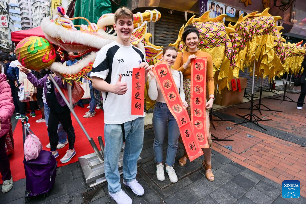 Overseas students pose for photos with Spring Festival couplets during an event celebrating the upcoming Chinese New Year at the Temple Street in south China's Hong Kong, Feb 4, 2024. Photo: Xinhua