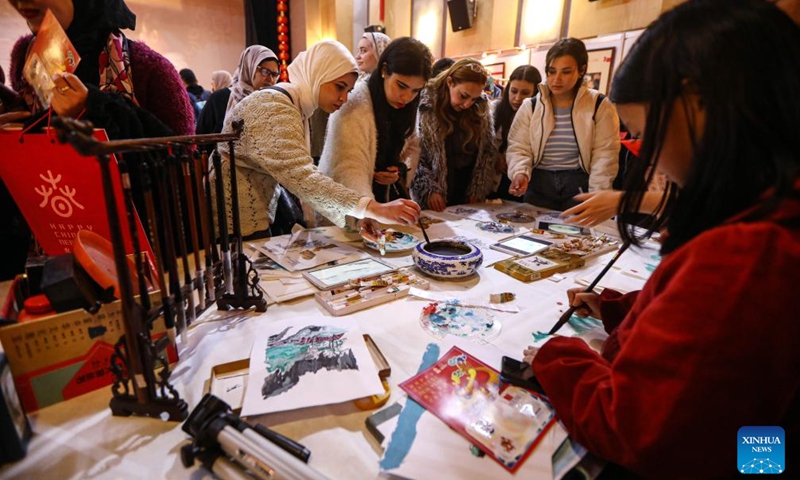Visitors try Chinese paintings during a celebration to mark the upcoming Chinese Lunar New Year in Cairo, Egypt, Feb. 3, 2024. The event, sponsored by the China Cultural Center in Cairo, was attended by about 80 participants from seven Egyptian provinces.(Photo: Xinhua)