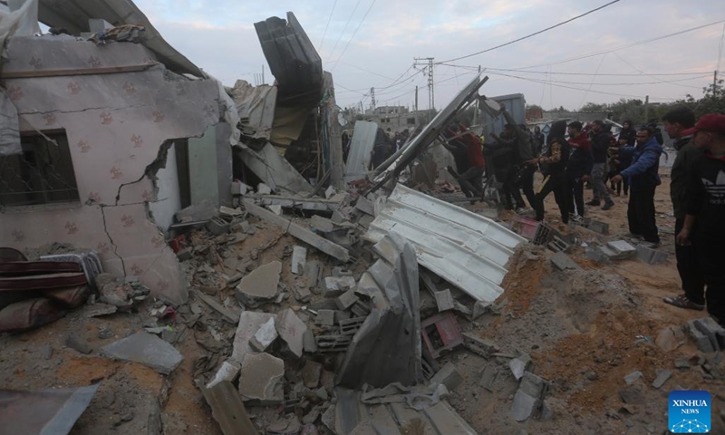 People gather around a destroyed house after an Israeli airstrike in the southern Gaza Strip city of Rafah, on Feb. 5, 2024. The death toll of Palestinians killed from Israeli strikes on the Gaza Strip has risen to 27,478, the Hamas-run Health Ministry said on Monday(Photo: Xinhua)