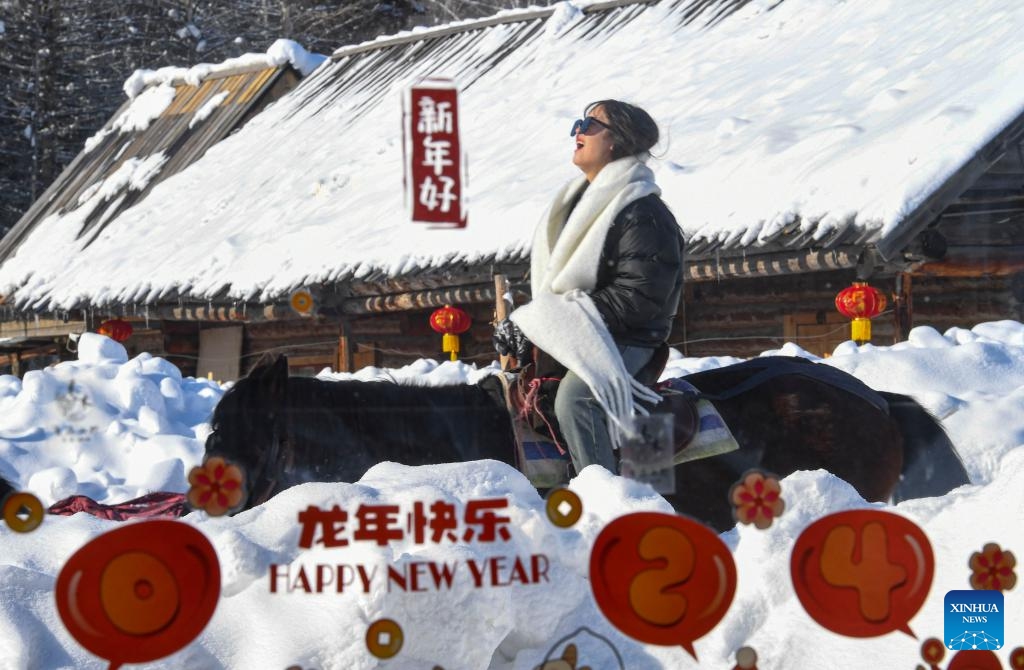 A tourist riding a horse passes a coffee shop in Hemu Village in Altay Prefecture, northwest China's Xinjiang Uygur Autonomous Region, Feb. 5, 2024. Tucked away within Altay Prefecture, Hemu Village in Xinjiang offers the perfect winter getaway. As the Spring Festival is approaching, the village has become a hot spot for tourists.(Photo: Xinhua)